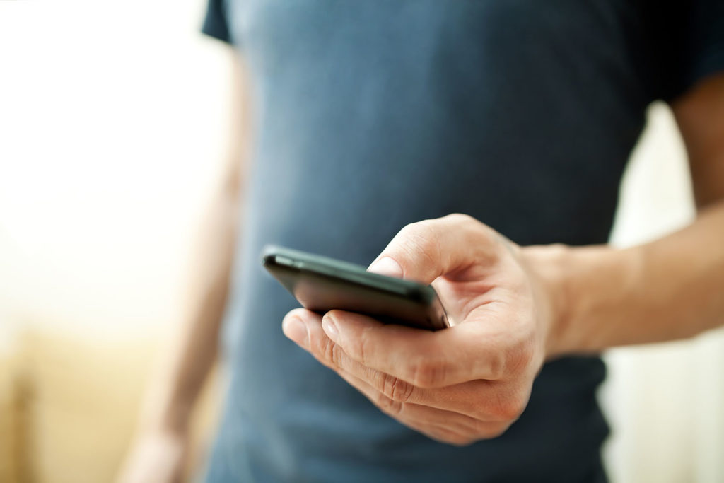 Close up of a man using mobile smart phone