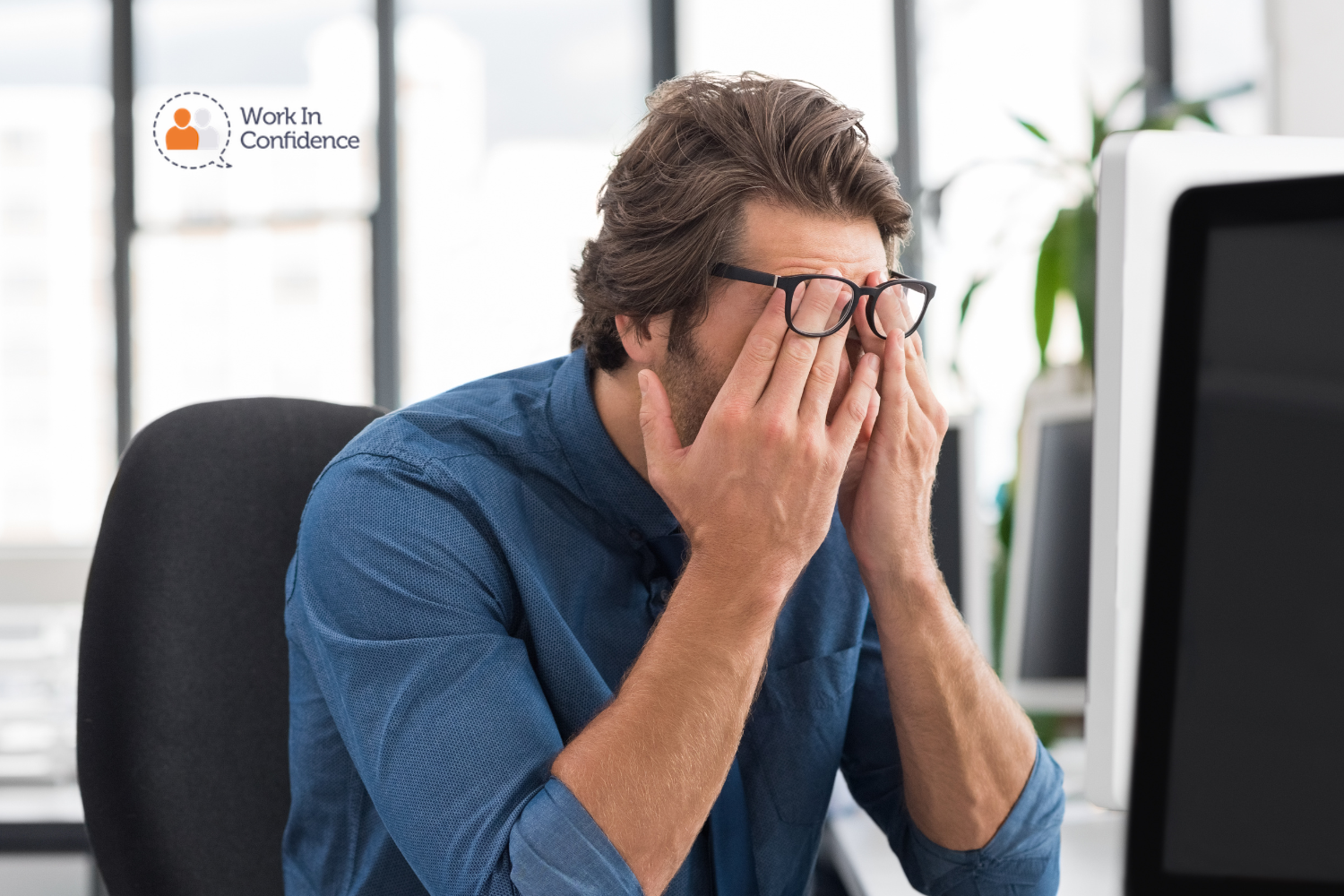 man looking stressed at computer rubbing his eyes