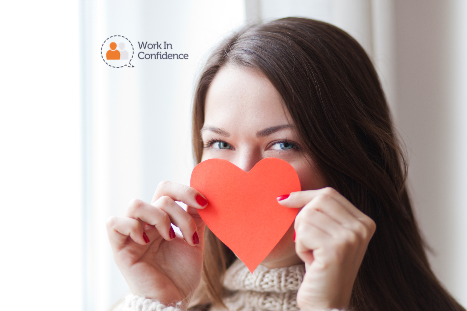 woman holding a paper love heart up to her face